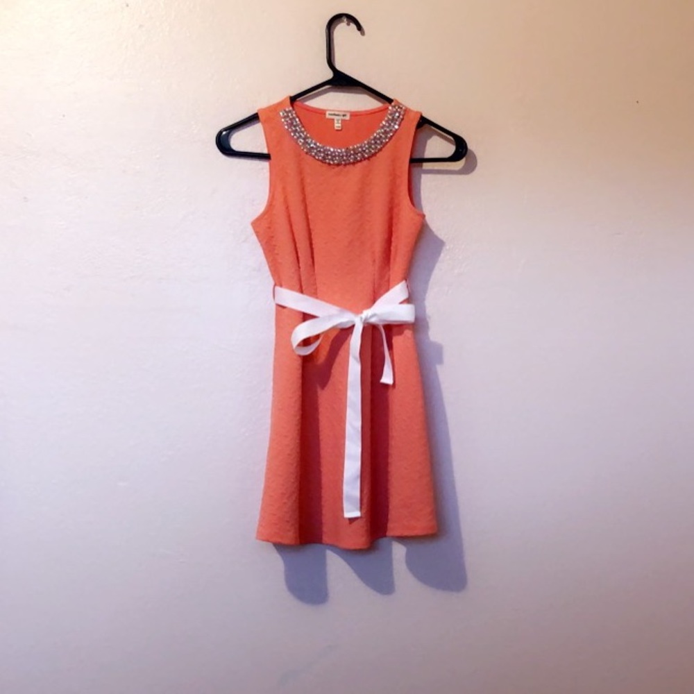 A coral dress with a white bow